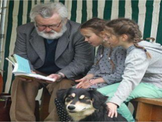 Enfants qui écoutent une histoire avec un chien et une personne âgée.